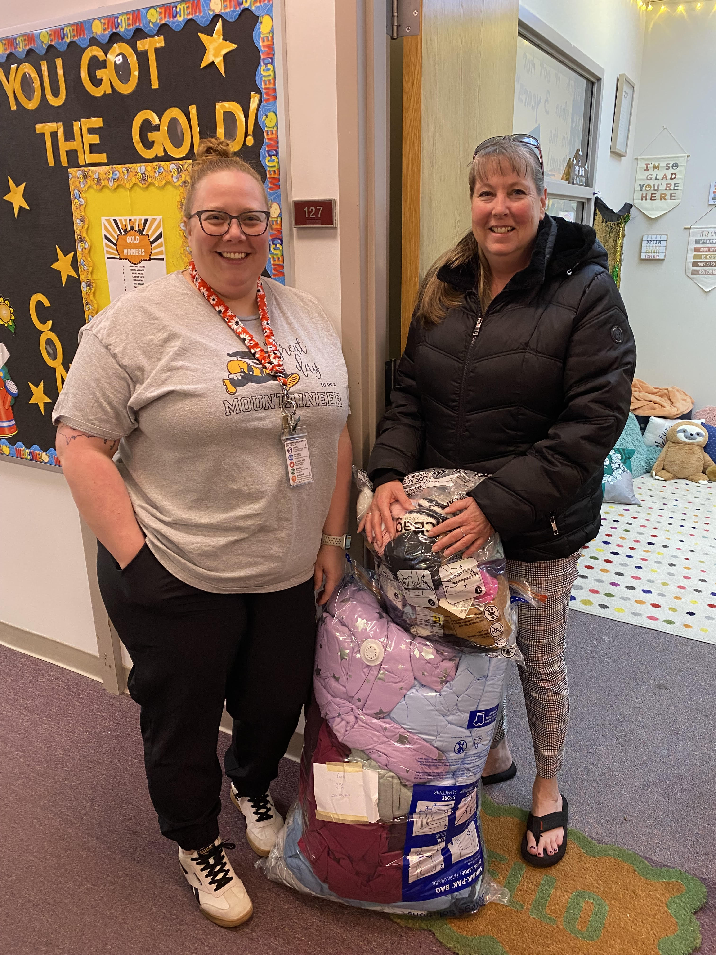 Earlene and Adrienne stand by bag of clothes and donations